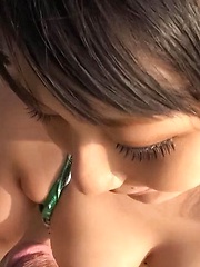 Megumi Haruka Asian busty strokes and licks dong head outdoor