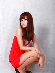 Sandy Asian on heels shows hot behind in red dress for pictures